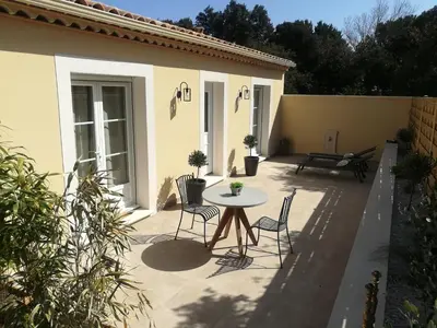 a patio with a table and chairs and a building at Le Mazet d'Olivia, escapade romantique en Provence in Châteauneuf-de-Gadagne