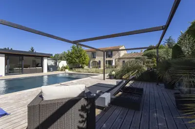 a patio with a couch and a swimming pool at Le Mas des Oliviers in Châteaurenard