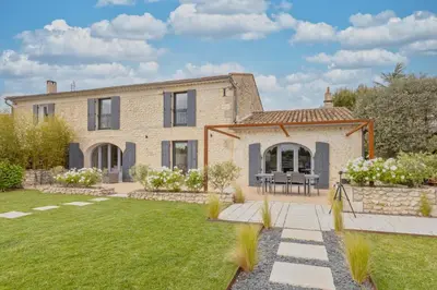 a stone house with a garden in front of it at Le Mas des Oliviers in Châteaurenard