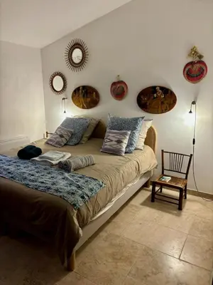 a bedroom with a large bed with two mirrors on the wall at Maison de charme avec piscine in Simiane-la-Rotonde