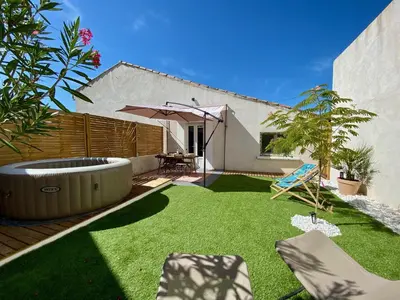 a small backyard with a lawn with a hot tub at Tiny Harmony - Logement confortable avec jardin et jacuzzi privés près d’Aix en Provence in Venelles