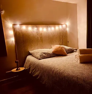 a bedroom with a bed with lights on it at Tiny Harmony - Logement confortable avec jardin et jacuzzi privés près d’Aix en Provence in Venelles