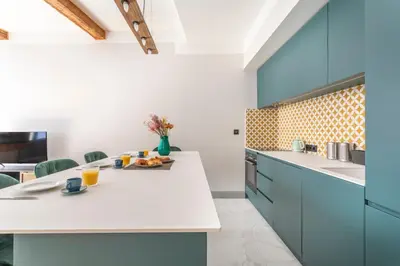 a kitchen with a white counter and blue cabinets at Magnifique appartement centre historique in Aix-en-Provence