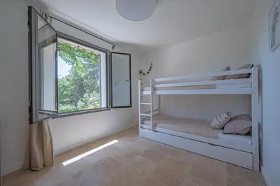 a bedroom with two bunk beds and a window at VILLA VOGA- Luxury family holidays Aix-en-Provence in Éguilles