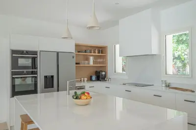a white kitchen with a bowl of fruit on a counter at VILLA VOGA- Luxury family holidays Aix-en-Provence in Éguilles