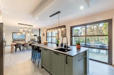 a kitchen with a large island and a dining room at Villa Feijoa en Provence in Velleron