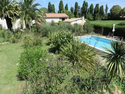 a garden with a swimming pool and plants at Appartement dans Mas Provencal in Grans