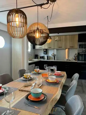 a dining room table with chairs and chandeliers at Maison de ville spacieuse & cosy in LʼIsle-sur-la-Sorgue