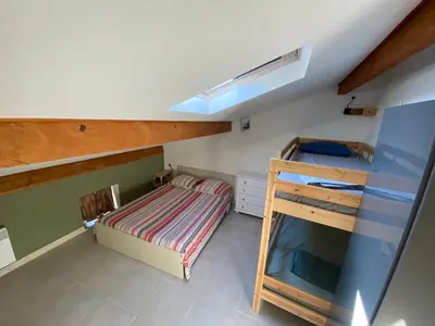 a small bedroom with a bunk bed and a ladder at Appartement climatisé au pied du Mont Ventoux in Malemort-du-Comtat