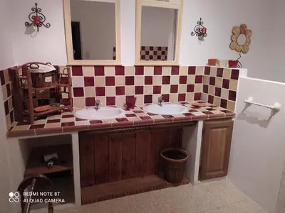 a bathroom with two sinks and a checkered counter at La maison de Nazig in Pertuis