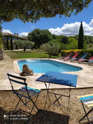 a group of lawn chairs and a swimming pool at La maison de Nazig in Pertuis