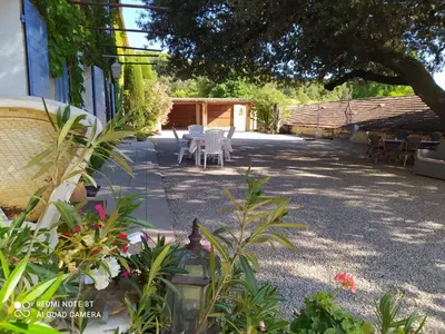 a patio with a table and chairs in a yard at La maison de Nazig in Pertuis