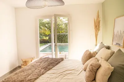 a bedroom with a bed and a large window at Maison Loutina, Villa 5 min à pied du centre in LʼIsle-sur-la-Sorgue