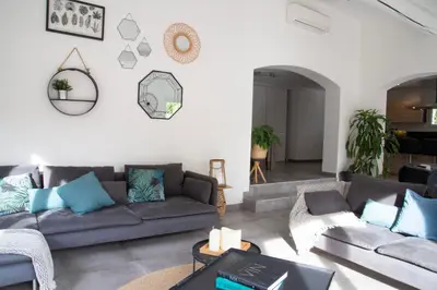 a living room with a couch and a table at Maison Loutina, Villa 5 min à pied du centre in LʼIsle-sur-la-Sorgue