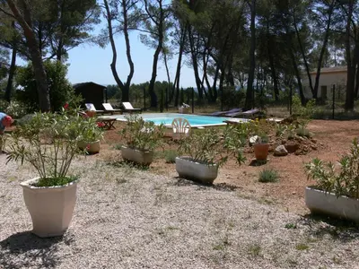 a garden with potted plants and a swimming pool at La Coudoulière in Saint-Rémy-de-Provence