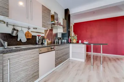 a kitchen with a table and a red wall at Le Blondel in Aix-en-Provence