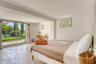 a bedroom with a bed and a large window at Le mas sous les étoiles in Joucas