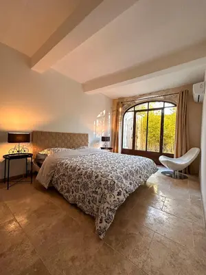 a bedroom with a bed and a large window at L'appart des Anges in Althen-des-Paluds