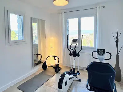 a gym with exercise equipment in a room with windows at provence living in Roussillon