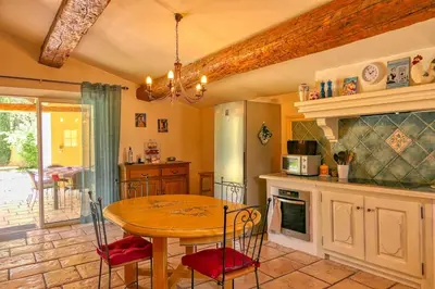 a kitchen with a wooden table and a table and chairs at Villa de Minna in Robion en Luberon