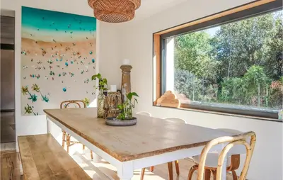 a dining room with a wooden table and a window at Nice Home In Pernes-Les-Fontaines in Pernes-les-Fontaines