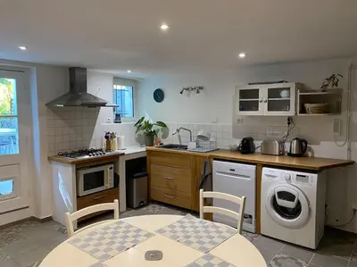 a kitchen with a washing machine and a washer at Montjoïa Le gîte bleu in Le Thor