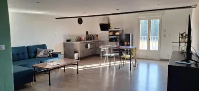 a living room with a blue couch and a kitchen at Loft en duplex au Mas de la Restanque in Monteux
