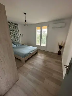 a bedroom with a bed and a wooden floor at L’Amistouso in Vedène