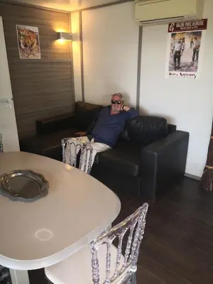 a man sitting on a couch in a room at GÎTE DE L 'OCRE NICE VIEW in Villars