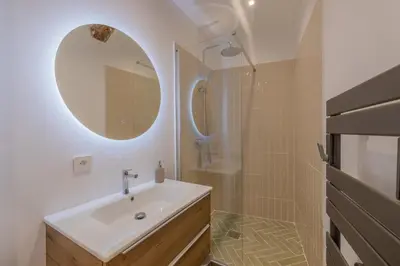 a bathroom with a sink and a shower with a mirror at Appartement de charme in Aix-en-Provence
