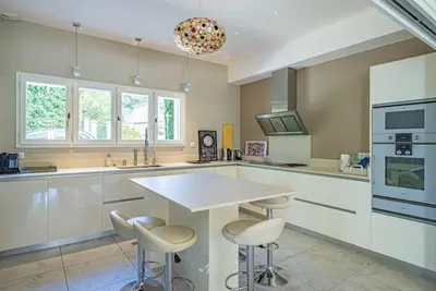a kitchen with a table and stools in it at Villa des Fontaines luxury family home with pool in Pernes-les-Fontaines