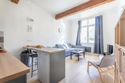 a kitchen and living room with a couch and a table at Studio place cardeurs in Aix-en-Provence