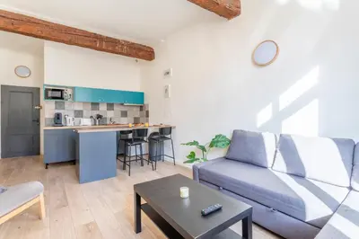 a living room with a couch and a table at Studio place cardeurs in Aix-en-Provence
