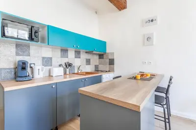 a kitchen with blue cabinets and a wooden counter top at Studio place cardeurs in Aix-en-Provence