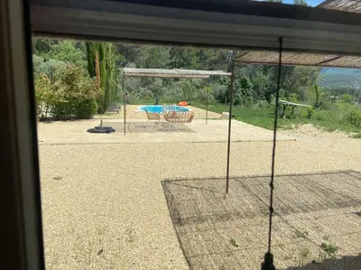 a view from a window of a backyard with a pool at Jolie maison avec vue imprenable, piscine, jeu de boules, calme au cœur du Luberon in Les Cordiers