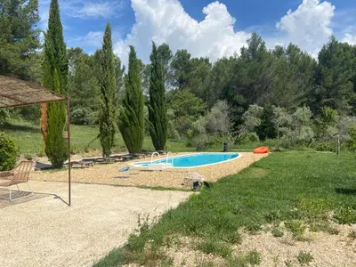 a backyard with a swimming pool and a lawn at Jolie maison avec vue imprenable, piscine, jeu de boules, calme au cœur du Luberon in Les Cordiers