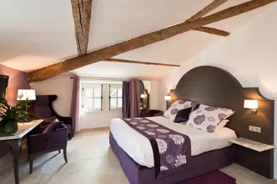 a bedroom with a bed and a table and a chair at Moulin de Vernègues Hôtel & Spa in Mallemort