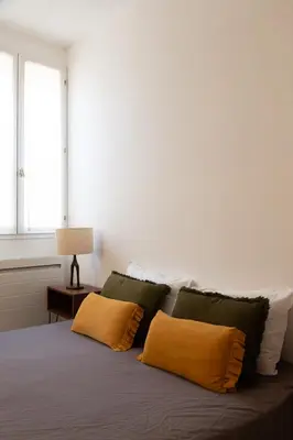 a bedroom with a bed with two pillows and a window at Maison de village Arty et terrasse au calme in Lourmarin
