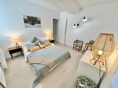 a bedroom with a bed and a living room at Maison de village Arty et terrasse au calme in Lourmarin