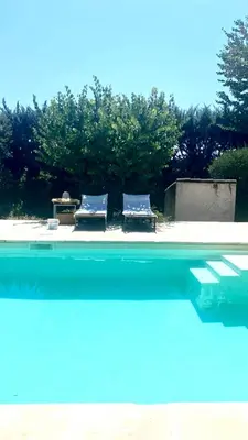 two blue chairs sitting next to a swimming pool at Charmante maisonnette avec jardin et piscine in Aix-en-Provence