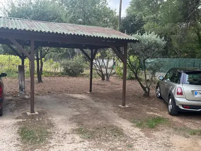 a car parked under a pavilion in a field at Charmante maisonnette avec jardin et piscine in Aix-en-Provence