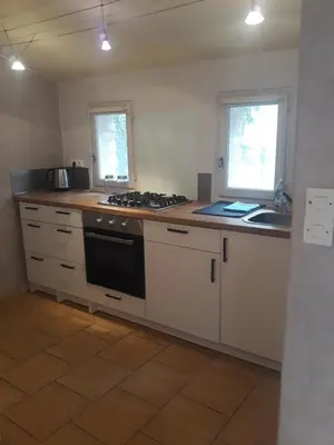 a kitchen with white cabinets and a stove top oven at La maison du jardin in Rustrel