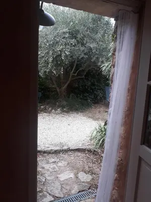 an open door with a view of a yard at La maison du jardin in Rustrel
