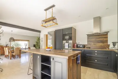 a kitchen with a island with a wooden counter top at Maison des Fleurs in Vedène