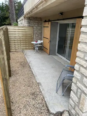 a patio with a table and a chair next to a building at Joli logement au pied des Alpilles in Eyguières