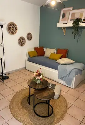 a living room with a couch and a table at Aix-en-Provence, Cosy Studio proche toutes commodités et axes routiers, linges fournis in Aix-en-Provence