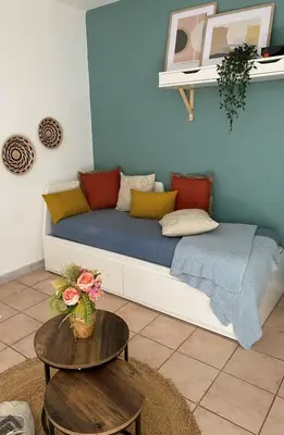 a blue couch with pillows on it in a room at Aix-en-Provence, Cosy Studio proche toutes commodités et axes routiers, linges fournis in Aix-en-Provence