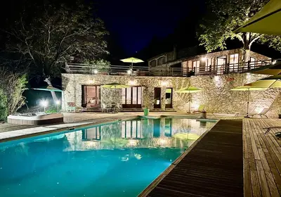 a swimming pool in front of a house at night at Gîte Nature en Luberon in Céreste