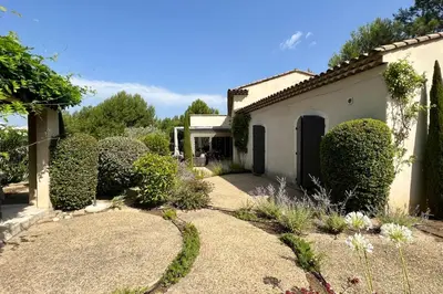 a house with a garden with trees and bushes at Maison Marie Provençal Elegance on the Pont Royal Golf Course in Mallemort