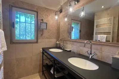 a bathroom with two sinks and a large mirror at Villa Maya Large villa and amazing pool in Luberon in Puget